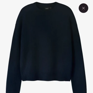 Mörkblå stickad tröja från LMTD - En enkel och stilren mörkblå stickad tröja från LMTD. Tröjan har rund halsringning, långa ärmar och ribbade muddar vid ärmslut och nederkant. Perfekt för lager-på-lager under kyliga dagar.