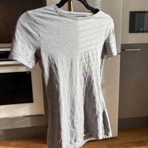 Grå t-shirt från Intimissimi, S - Snygg grå t-shirt från Intimissimi i mjuk Supima-bomull. Modellen är klassisk med rund hals och korta ärmar, perfekt för en clean och enkel look. Passformen är normal och materialet känns riktigt skönt mot huden.