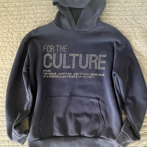 suuuupperrr nice hoodie!! - Säljer en mörkblå hoodie med texten 'FOR THE CULTURE' i stora bokstäver framtill, dekorerad med små stenar, det finns några små fläckar på baksidan men inget man tänker på