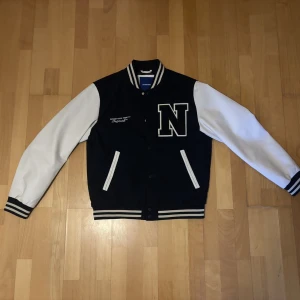 mörkblå vit bomberjacka Jack & Jones  - Säljer en svartvit bomberjacka från Jack & Jones med stora vita ärmar och mörkblå kopp. Perfekt för dig som diggar en unik stil, vid intresse hör av er!