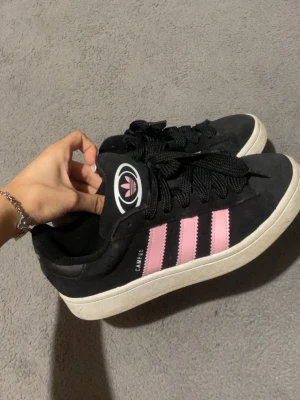 Adidas Campus   - Säljer ett par Adidas Campus i svart rosa ränder och vit sula. Köpta för 900kr å säljs för 600kr, går att tvättas förhand. skriv om ni har frågor ❤️