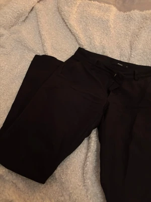 Svarta kostymbyxor från Bik Bok - Svarta kostymbyxor från Bik Bok i modellen Vera low waist regular. Byxorna är i ett bra sick utan tecken på slitage. 