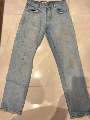 Woodbird ljusblå jeans, storlek 26/30 - Säljer ett par ljusblå jeans från Woodbird. Jeansen har raka ben, normal passform  , raka ben. Dessa jeans är äldre och slitna ( skador syns i bilderna) Storlek 26/30. 