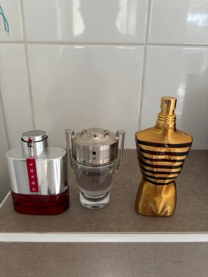 Tre populära herrparfymer - Snyggt set med tre ikoniska herrdofter från Prada, Paco Rabanne (Invictus) och Jean Paul Gaultier. Perfekt för dig som vill ha klassiska och trendiga parfymer i samlingen. Volym och ingredienser syns ej på bilderna.