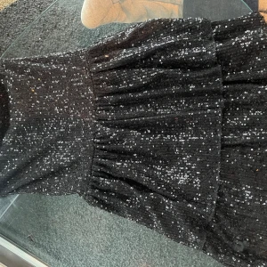 Svart glittrig klänning  - Säljer en svart klänning från Gina Tricot med massor av paljetter  Perfekt inför nyår eller för dig som vill sticka ut på festen! Klänningen är i storlek 158-164.!Skriv till mig för ytterligare frågor!😊🫶🩷