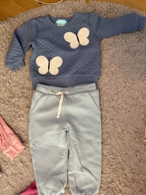 Ljusblå mjukisbyxor med snörning - Säljer ett par ljusblå mjukisbyxor med bekväm resår i midjan och vit snörning framtill. Byxorna har en avslappnad passform och är gjorda i mjukt bomullsmaterial, perfekta för chill dagar. Fickor på sidorna för extra funktion.