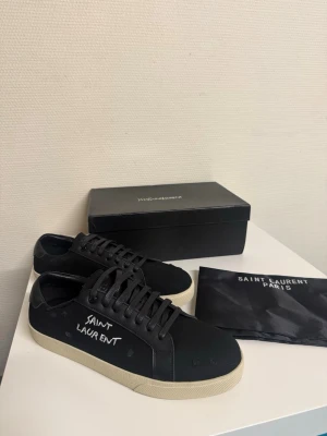 Svarta Saint Laurent sneakers - Ett par snygga skor från Saint Laurent. Skorna är i princip oanvända och riktigt fräscha. Tveka inte på att skriva för fler bilder eller om du undrar något😁