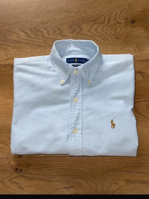 Ljusblå Ralph Lauren skjorta - Tjena! Säljer denna skjorta då jag fick den som julklapp i fjol men jag använde den knappt! Skjortan är i väldigt bra skick med inga synliga defekter! Storleken är S/P Classic Fit och passar riktigt fint till många outfits! Pris kan diskuteras vid snabbt köp! Vid funderingar och frågor är det bara att höra av sig!