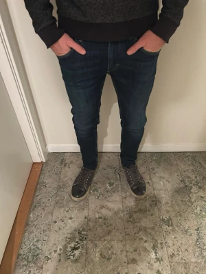 Mörkblå slim jeans från tiger of Sweden - Snygga mörkblå jeans från tiger of Sweden med klassisk femficksdesign och smal passform. Jeansen har en slimsiluett och är tillverkade i stretchigt denim för extra komfort. Perfekta för dig som gillar en modern och tajt look.