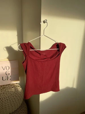 Vinröd linnetopp från Brandy Melville - Säljer en vinröd linnetopp från Brandy Melville med breda axelband och mjuk, stretchig känsla. Toppen är ärmlös och har en snygg, enkel design som är lätt att matcha. Materialet är bomull och bara använd några gånger men knappt 💞