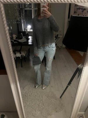 Grå stickad tröja - Mysig grå stickad tröja med långa ärmar. Materialet är mjukt och bekvämt, perfekt för kyligare dagar.