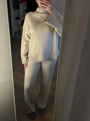Stickat set  - Jag säljer ett beige stickat set. Det är jätte stretchigt och passar storlekar mellan S-L. Byxorna passar mig perfekt och jag är 170 cm lång. Använt några gånger bara.