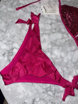 Rosa bikini från Calzedonia med paljetter - Säljer nu min snygga rosa bikini från Calzedonia med trekantsöverdel och knyt i sidorna på underdelen. Den är helt ny me prislapparna kvar. Aldrig använd🥰