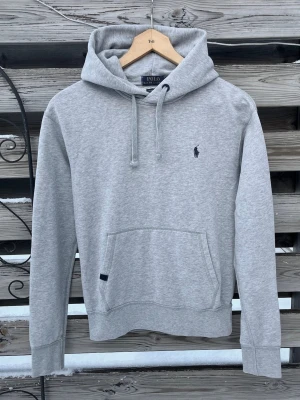 Grå Ralph Lauren Hoodie  - Riktigt snygg Ralph Lauren Hoodie🔥. Storlek XS. Väldigt fint skick förutom en liiiiiiten ”fläck” (sista bilden, inget som syns irl). Mjuk o härlig hoodie. Perfekt nu till vintern!☃️ Hör gärna av er vid funderingar🙌🏻🩶