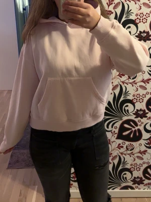 Ljusrosa hoodie med magficka - Säljer en ljusrosa hoodie med klassisk huva och magficka, bred i midjan. Använd ett få antal gånger💕