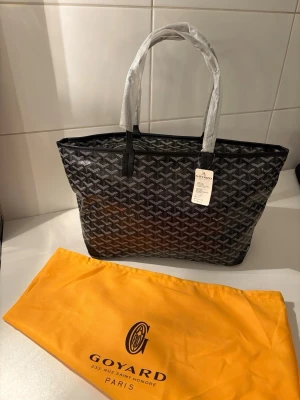 G Handväska som är i svart färg - Säljer en handväska som är i väldigt fint skick och med etiketter som redan sitter på och där det följer med en dustbag.