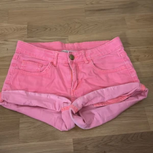 rosa jeansshorts - Snygga rosa shorts i denim med upprullad kant och klassisk femficksmodell. De har knapp och dragkedja framtill samt bälteshällor i midjan. Perfekta för varma dagar och ger en färgstark touch till din outfit.