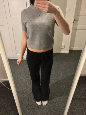 Grå croppad stickad topp från Zara - Grå croppad stickad topp från Zara med korta ärmar och rund halsringning. Perfekt att styla med höga byxor eller kjol för en trendig look. Mjuk och skön känsla tack vare det stickade materialet.