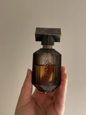 Hugo Boss The Scent parfym | Eau de Parfum - Elegant parfym från Hugo Boss, The Scent Absolute. Top Notes: Honeyed Peach Heart Notes: Coffee Base Notes: Vanilla, Vetiver. Cirka 15ml av 30ml. Kryddig, sensuell & doftar fräscht. ❄️ super god doft! Packas omsorgsfullt. Nypris : 945:-(!!). Säljs för 250:- ✨