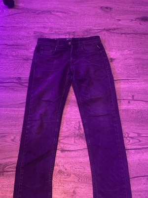 Mörkgråa slim replayjeans W 28 L 30 - Snygga mörkgråa jeans med raka ben och klassisk femficksdesign. Jeansen har slim passform och är tillverkade i slitstarkt denimtyg. Perfekta för dig som gillar en enkel och tidlös look. Dom har W 28 med L 30