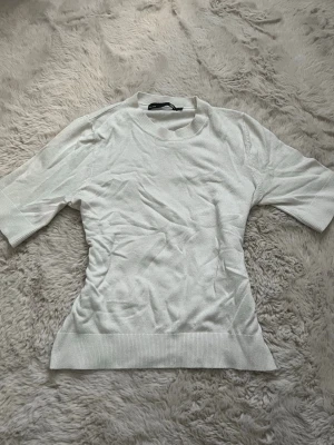 Vit ribbad topp  - Säljer en vit, croppad topp från 157 i storlek XS. Toppen har ribbad kant vid hals och nederdel, korta ärmar och en enkel, clean design. Perfekt att matcha med jeans eller kjol för en chill look. Materialet är mjukt och stretchigt, vilket gör den skön att bära🫶🏼