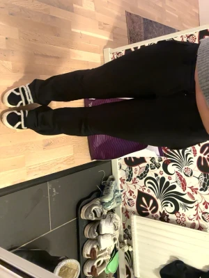 Svarta bootcut kostymbyxor med låg midja - Snygga svarta bootcut kostymbyxor och klassisk design. Byxorna har fickor i sidorna och bälteshällor i midjan. Perfekta för en stilren look och lätta att matcha med olika toppar. OBS På insidan av byxorna finns det ett litet märke pga ett strykjärn men annars är byxorna helt fantastiska! Pris kan diskuteras🙌