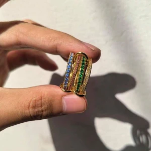 Färgglada guldiga statementringar - Unika statementringar i guldton med flera band sammanlänkade av runda ringar. Utsmyckade med gnistrande stenar i blått, grönt, rosa och gult. Perfekt för dig som vill sticka ut med färg och cool design. Säljs som set.