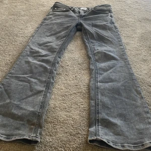 Grå bootcut jeans från Grunt - Snygga grå jeans från Grunt med bootcut-passform och klassisk femficksdesign. Jeansen har en cool tvättad look och är tillverkade i mjukt denimtyg. Kontakta vid frågor eller funderingar !