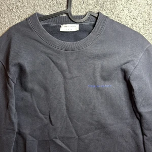 Blå sweatshirt från Tiger of Sweden - En stilren svart sweatshirt från Tiger of Sweden med diskret logga på bröstet. Tröjan har rund halsringning, långa ärmar och ribbade muddar. Perfekt för dig som gillar minimalistisk och clean stil. Köpte den för 1100kr på zalando. Passar inte mig längre. Passar om du är runt 170