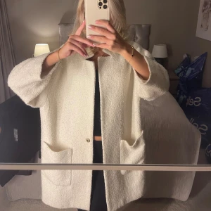 Oversized vit teddyjacka med fickor - Säljer en oversized vit teddyjacka med stora framfickor och enkel knappstängning. Jackan har en rak och loose passform, trekvartsärmar ish och är tillverkad i mjukt teddy-material. 