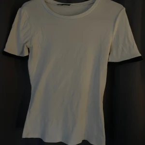 Vit topp med svarta spetsdetaljer från Zara  - Vit kortärmad topp från Zara med svarta virkade spetsdetaljer längst ut på ärmarna. Toppens material känns mjukt och stretchigt. Jätte fin och helt slutsåld, säljs för att den inte kommer till användning. Kontakta för egna bilder.
