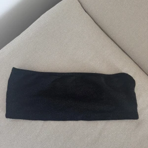 Svart glittrig kort topp NA-KD - Supersnygg svart kort topp från NA-KD med glittrigt tyg. Toppen har en enkel och tight passform