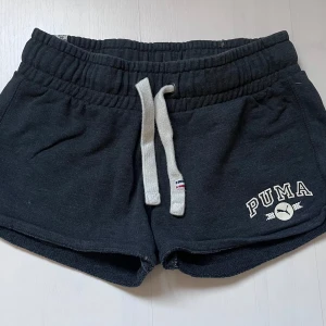 Svarta shorts från Puma med snörning - Svarta mjukisshorts från Puma med vit snörning i midjan. Inte använda mycket så dom är fortfarande i bra skick