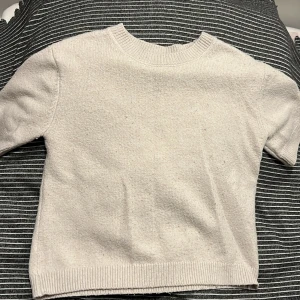 Vit stickad tröja från Kappahl - En stilren vit stickad tröja från Kappahl i storlek 170. Tröjan har rund halsringning, ribbade muddar och är perfekt för lager-på-lager. Enkel och klassisk design som funkar till allt.