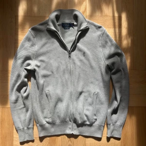 Grå Full-zip från Ralph Lauren - En fin grå full-zip från Ralph Lauren. Storlek S. Hör av er ifall ni har några frågor!