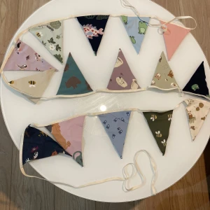 Babyvimpel- NY - babyvimpel handsydd av en skicklig sömmerska från ett jersey mönstrat babyplagg. Istället för att företaget bränner överblivna plagg skapar sömmerskan något nytt och vackert.  Mått: Längd 450 cm, bredd 16 cm Användning: Barnrum, inredning, styling – du bestämmer