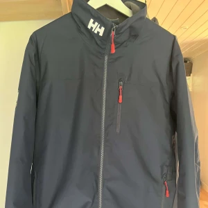 Helly Hansen jacka  - En blå Helly Hansen jacka. Jackan är i väldigt bra skick och är knappt använd. Hör av er vid fler frågor. 