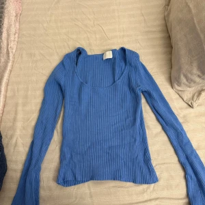 Blå ribbad långärmad topp - Snygg blå långärmad topp med ribbat tyg och rundad urringning. 