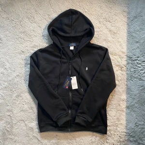 Svart Hoodie Polo Ralph Lauren - Helt ny Polo Ralph Lauren‑hoodie i svart med etiketter kvar. Priset kan diskuteras   ⭐️ Skick: 10/10 oanvänd  🎲 Storlek: M 📦 Frakt: samma / nästa dag