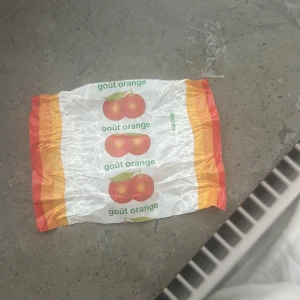 Godis  - Bilderna visar ett godispapper med texten 'goût orange' och bilder på apelsiner. Ingen elektronikprodukt syns på bilderna, och inga tekniska specifikationer, märke eller modell kan identifieras.