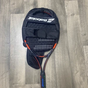 Ballfighter 25 - Babolat Ballfighter 25 tennisracket i mycket fint skick, perfekt för juniorer. Levereras med original fodral för enkel transport och skydd. Racketet har fräscha strängar och handtag, inga synliga skador eller slitage. Snygg design med färgglada detaljer.