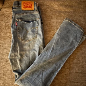 Levi's 510 Skinny ljusblå jeans 164cm - Ljusblå Levi's 510 Skinny jeans med klassisk femficksdesign och snygga kontrastsömmar. Modellen är smal och sitter tajt längs benen. Ikonisk läderpatch bak i midjan och Levi's-röd etikett på bakfickan. Perfekta för dig som gillar en modern och clean look.