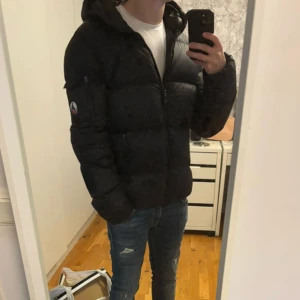 JOTT dunjacka - Svart dunjacka från JOTT i storlek M. Den har använts några gånger under en vinter och är i mycket bra skick utan tydliga tecken på användning. Passar dig som är cirka 178-183cm. Nypris ligger på strax över 3000kr. Hör av dig vid frågor eller funderingar!