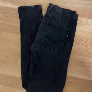 Replay Anbass svarta jeans - Svarta Replay Anbass jeans i klassisk femficksmodell. Jeansen har en snygg tvättad finish, raka ben och diskreta detaljer som logga på bakfickan. Tillverkade i stretchig denim för skön passform. Perfekta för dig som gillar stilrena och moderna jeans. Waist 32 length 32 pris kan diskuteras 