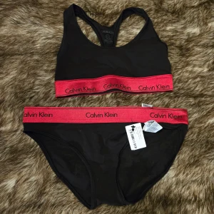 Calvin Klein set - OANVÄNDA‼️ Svart Calvin Klein set med bred röd resår och logga runt underkanten. Toppen är storlek S och trosan är storlek M