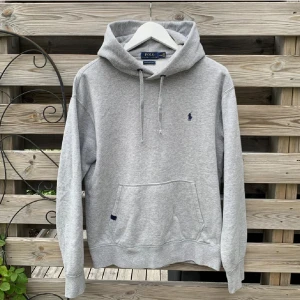 Ralph Lauren Grå Hoodie - Säljer denna riktigt feta Hoodie från Ralph Lauren. Storlek M, sitter exakt som en vanlig S. Riktigt härlig och mjuk, väldigt fint skick, men kan eventuellt ha nån minimal ytlig fläck som enkelt går bort med tvätt (är inte säker på om det finns fläckar). Tvätta isåfall tröjan. Knappt använd. Hör gärna av er vid funderingar🙌🙌