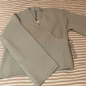 Grå omlottkofta från Meet Me There - Säljer en stilren grå omlottkofta från Meet Me There i stickat material. Säljer då den inte va riktigt min stil🥰 endast testad