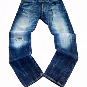 Grisch Diesel Black Gold blå jeans, straight fit - Säljer ett par blå Diesel Black Gold jeans med snygga slitningar och lagade detaljer på benen. Jeansen har klassisk femficksdesign, raka ben och tydliga kontrastsömmar. Materialet är robust denim i 100% bomull och passformen är straight fit. Skicka meddelande för mått eller andra frågor :)