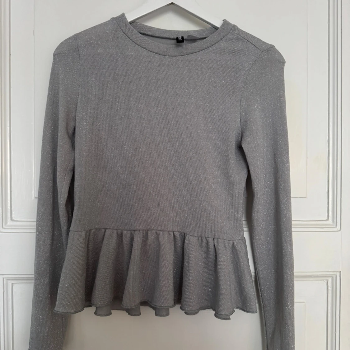 Glittrig silver topp med volang från H&M