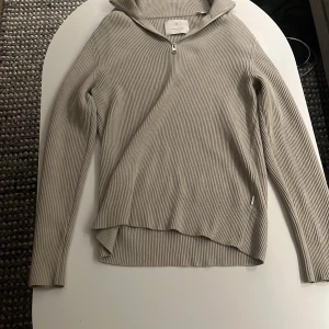 Beige ribbad half zip från Jack & Jones - Säljer en stilren beige ribbad tröja från Jack & Jones med half zip och hög krage. Tröjan är långärmad och har en normal passform, perfekt för lager-på-lager under höst och vinter. Materialet är mjukt och skönt, troligtvis bomull eller polyester. Personen på bilden är 175-177